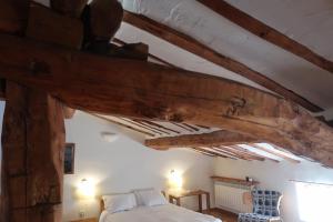 1 dormitorio con cama y techo de madera en Casa Barría, en Pradoluengo