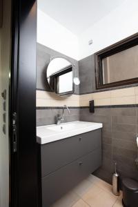 a bathroom with a sink and a mirror at Panorama Loft in Chalkida