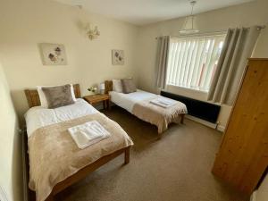 1 dormitorio con 2 camas y ventana en Cherry Tree Lodge, en Norwich