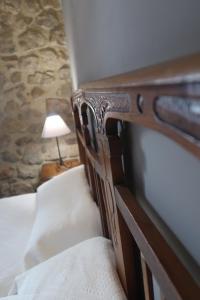 
a bed with a wooden headboard and pillows at Casa Barría in Pradoluengo
