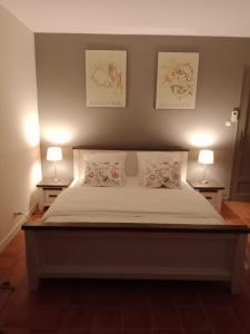 a bedroom with a bed with two lamps on two tables at les Bartavelles in Roussillon