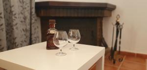 dos copas de vino sentadas en una mesa junto a una botella en Alojamiento Rural el Respiro "Calma", en Benaocaz