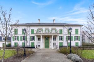 a large white house with a green door at Disneyland-Paris, 8pers, Wifi, Netflix, 2 Parkings in Serris