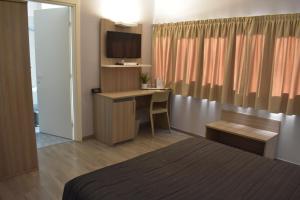 una camera d'albergo con letto e scrivania di Hotel Meuble' Atlantic a Treviglio
