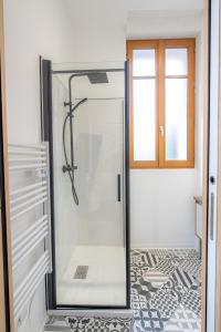 a shower with a glass door in a bathroom at L'avant-gardiste - Appart'Hotel Le Gatsby in Saint-Quentin