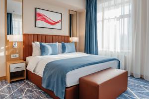1 dormitorio con cama y ventana grande en Ramada by Wyndham Astana en Astaná