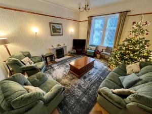 a living room with a christmas tree and two couches at Convalmore House in Dufftown