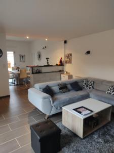 ein Wohnzimmer mit einem Sofa und einem Tisch in der Unterkunft chez fifi in Saint-Brevin-les-Pins