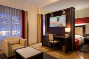 a hotel room with a bed and a desk and a tv at ACHAT Sternhotel Bonn in Bonn