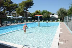 a young girl in a swimming pool at Camping Village Adriatico Giulianova in Giulianova