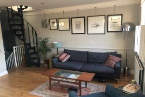 uma sala de estar com um sofá azul e uma mesa em Stylish and Spacious Apartment with Terrace em Londres