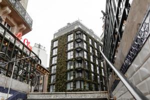 un grand bâtiment avec des plantes sur son côté dans l'établissement La Belle Ville, à Paris