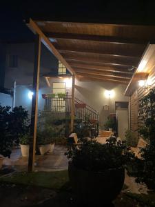 eine Terrasse in der Nacht mit einer hölzernen Pergola in der Unterkunft Hotel Rehovot in Rechovot