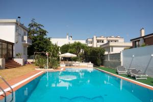 a large swimming pool with blue water in a building at PURA B&b in Noicattaro