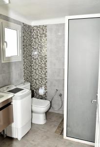 a bathroom with a toilet and a sink and a shower at BUNGALOW El HOUDA in Hammamet