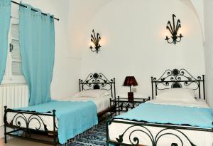 two beds in a bedroom with blue and white at BUNGALOW El HOUDA in Hammamet