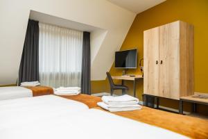 una camera d'albergo con due letti e una scrivania di Hotel Onder De Linden a Roden Altre 77 foto