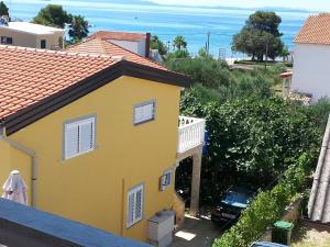 a yellow house with a view of the ocean at Apartment Sun in Vir