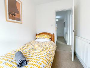 a bedroom with a bed with a yellow and white comforter at Spacious 2-bed Apartment in Crewe by 53 Degrees Property, ideal for Business & Professionals, FREE Parking - Sleeps 3 in Crewe