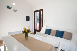 sala de estar blanca con mesa y sofá en Villa del Porto La Terrazza, en Portoscuso