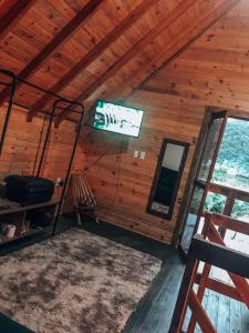 パリョサにあるCabana do Embaú Experienceの木造キャビン内のテレビ付きの部屋