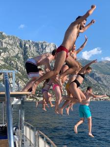 a man jumping in the air over a body of water at Old Town Youth Hostel in Kotor