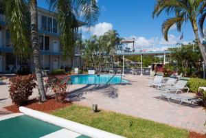 um resort com piscina e cadeiras e um edifício em FortLauderdale Beach Apartment em Fort Lauderdale