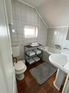 een badkamer met een toilet, een wastafel en een bad bij Kuća za odmor IVKOVIĆ in Kupres