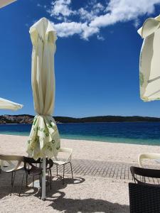 una playa con sillas y sombrilla y el océano en Villa Mira Trogir, en Trogir