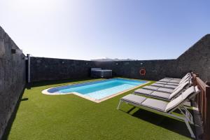 basen z leżakami przy ścianie w obiekcie Villa Penguina Play Blanca Lanzarote w mieście Playa Blanca