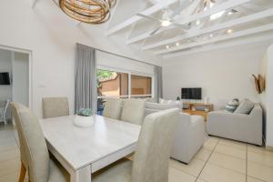 a dining room with a white table and chairs at San Lameer Villa 2609 - 3 Bedroom Superior - 6 pax - San Lameer Rental Agency in Southbroom