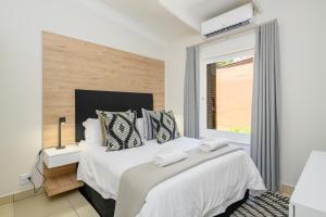 a bedroom with a large bed with a window at San Lameer Villa 2609 - 3 Bedroom Superior - 6 pax - San Lameer Rental Agency in Southbroom +40 photos