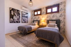 dwa łóżka w pokoju z dwoma oknami w obiekcie Villa Penguina Play Blanca Lanzarote w mieście Playa Blanca +37 zdjęć
