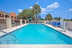 a swimming pool with blue chairs and a resort at Travelodge by Wyndham Suites St Augustine in St. Augustine