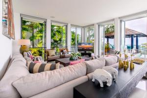 duży salon z dużą kanapą i stołami w obiekcie Surin Heights Villa w mieście Surin Beach
