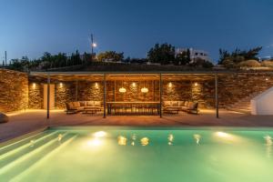 a villa with a swimming pool at night at Blue Gres Villa Tinos in Tinos
