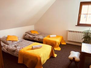Habitación con 2 camas con sábanas amarillas y ventana en Domy całoroczne Osada na Górce, en Ustrzyki Dolne