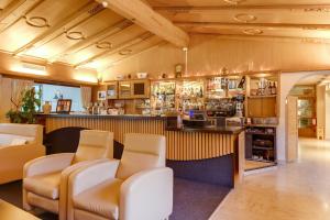 eine Bar mit Stühlen und einer Theke in einem Zimmer in der Unterkunft Smy Koflerhof Wellness & Spa Dolomiti in Oberrasen