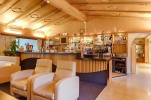 un bar con sillas y una barra en una habitación en Smy Koflerhof Wellness & Spa Dolomiti, en Rasun di Sopra