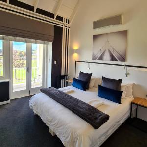 a bedroom with a large white bed with blue pillows at Boschenmeer House in Paarl