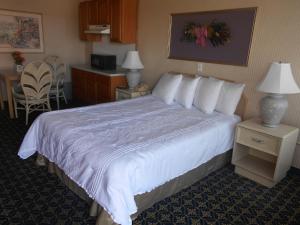 a hotel room with a large bed with white sheets at Victorian Inn in Reno