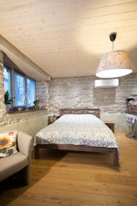 Un dormitorio con una cama y una pared de piedra. en Saue 1 Apartment, en Tallin