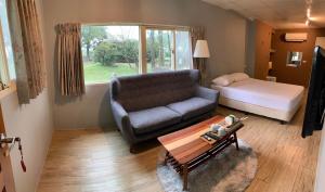 un soggiorno con un divano e un letto di 菜爺爺親子蔬宿Vegepapa B&B a Jiaoxi