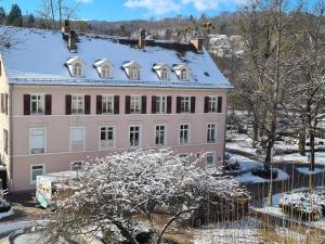 a large pink building with snow on its roof at Hotel Löhr in Baden-Baden