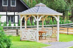 a gazebo with a table and chairs in a yard at Pastelowy Domek in Załakowo