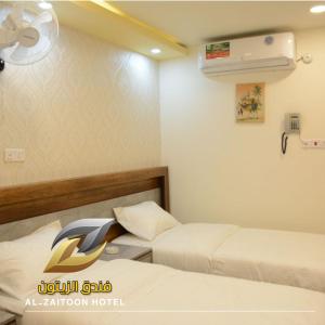 a hotel room with two beds and a fan at Al-Zaitoon Hotel and Restaurant فندق ومطعم الزيتون in Ḩujrat Farhūd