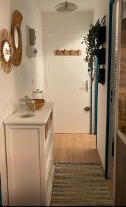 une cuisine avec un comptoir blanc et une porte dans l'établissement Appartement T2 27m² meublé vue mer, 50m de la plage, à Narbonne