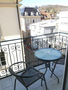 una mesa azul y sillas en el balcón en Hotel Löhr en Baden-Baden
