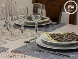 una mesa con platos y copas de vino. en Quinta das Perdizes, en Ponta Delgada