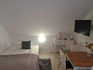 a small room with a bed and a desk with a television at Hotel Löhr in Baden-Baden